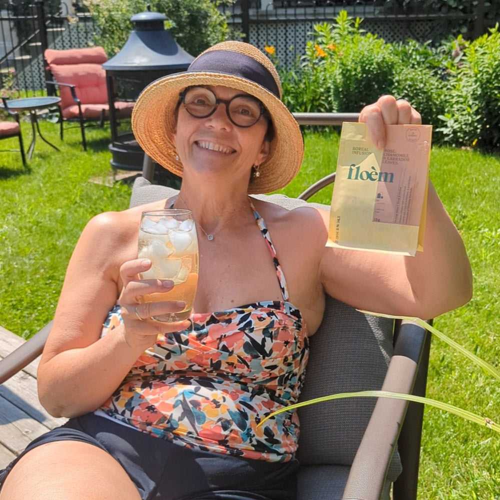 Cliente Floèm qui tient un sac de thé dans sa main dans son jardin