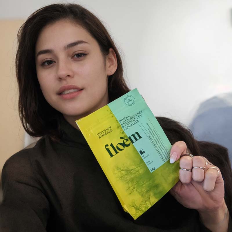 Cliente de Floèm souriante tenant un produit à la main